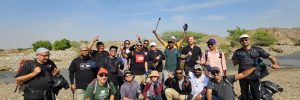 group of individuals poses after desert cleaning activity in Abu dhabi