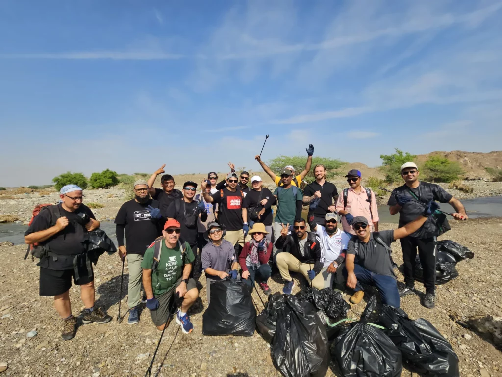 group of individuals poses after desert cleaning activity in Abu dhabi