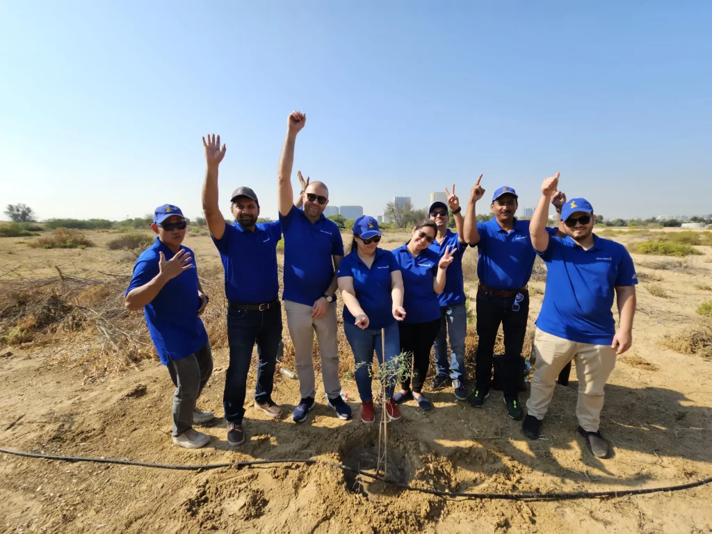 group of people posing while planting mangrove