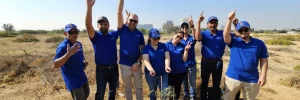 group of people posing while planting mangrove