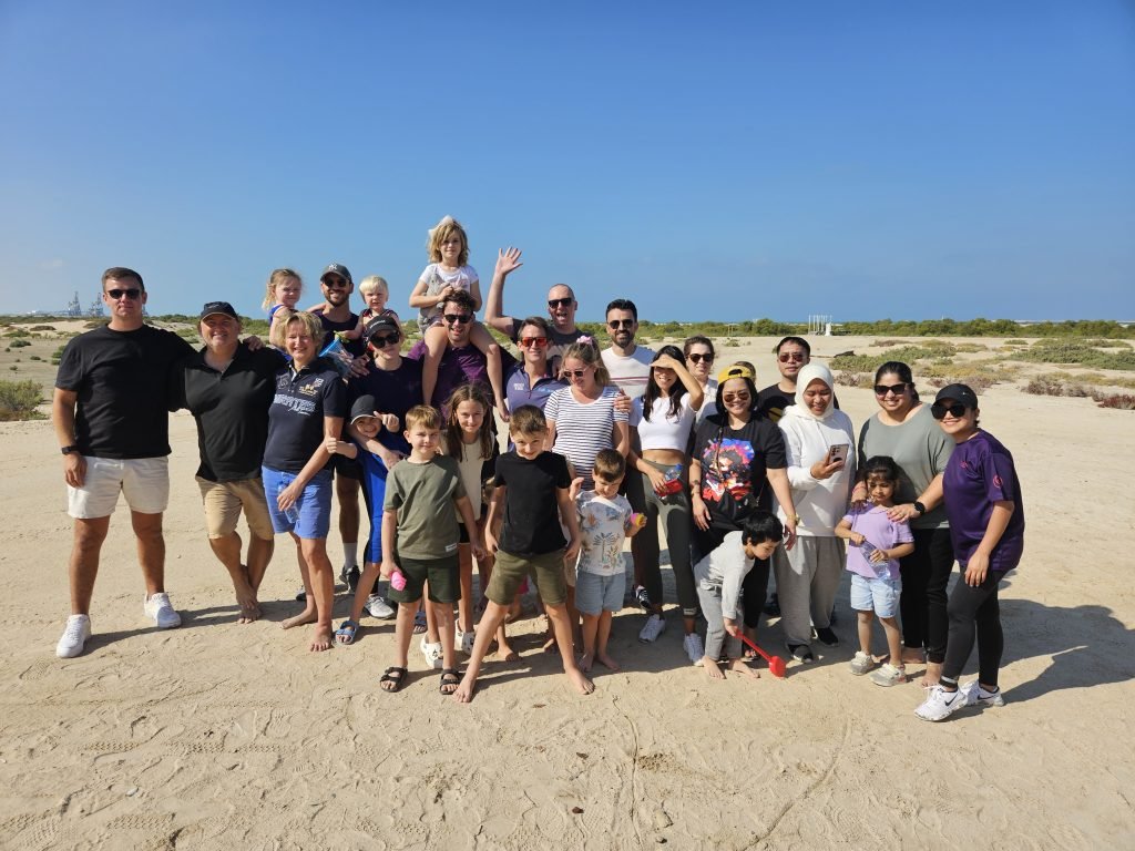 group of people happily faces after desert cleaning activity in dubai