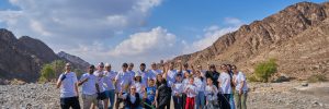 group of individuals poses after desert cleaning activity in dubai