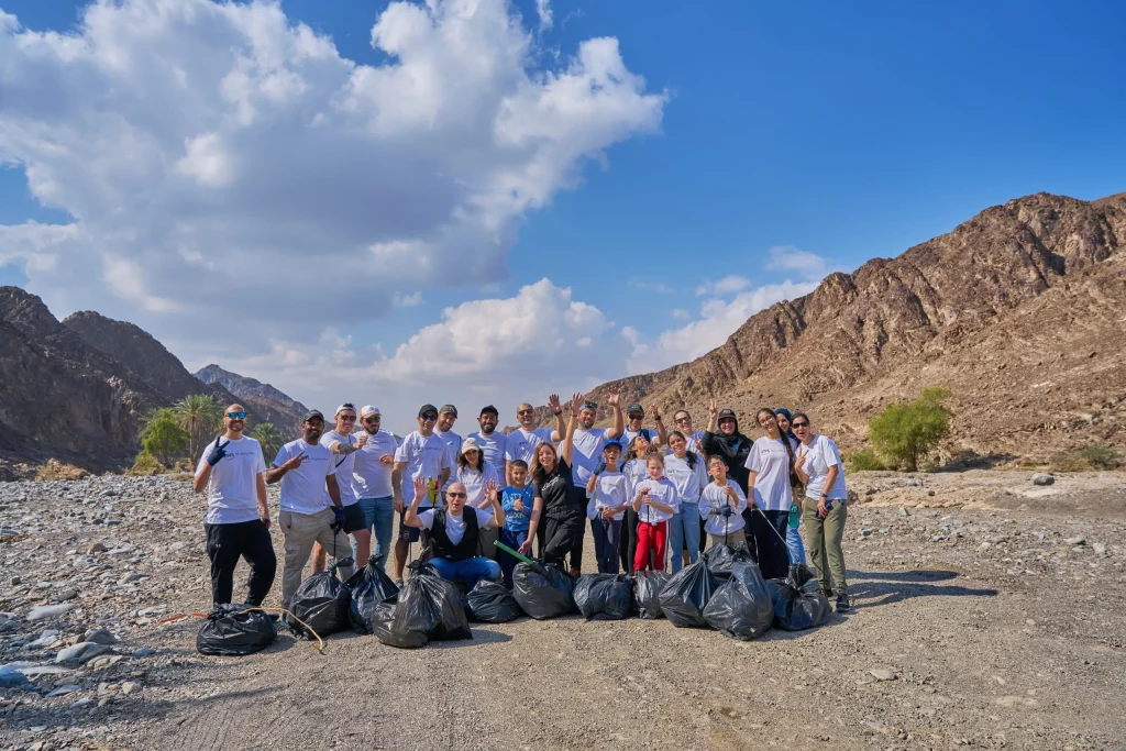 group of individuals poses after desert cleaning activity in dubai
