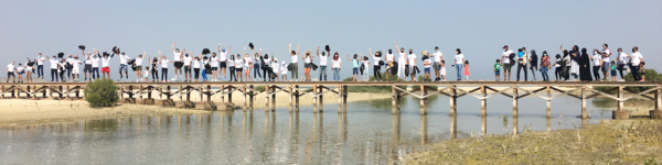 group of individuals stands on a bridge while doing team activities in dubai