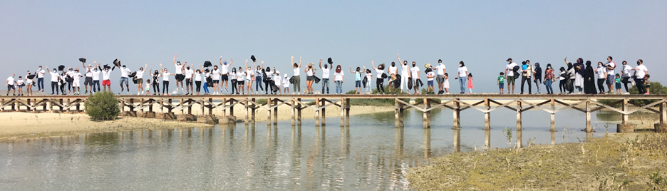 group of individuals stands on a bridge while doing team activities in dubai