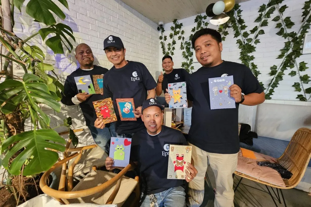 Men poses with hand made cards in their hand