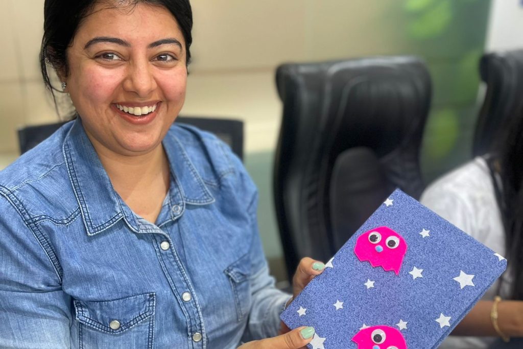 A lady happily showing hand made card made by her