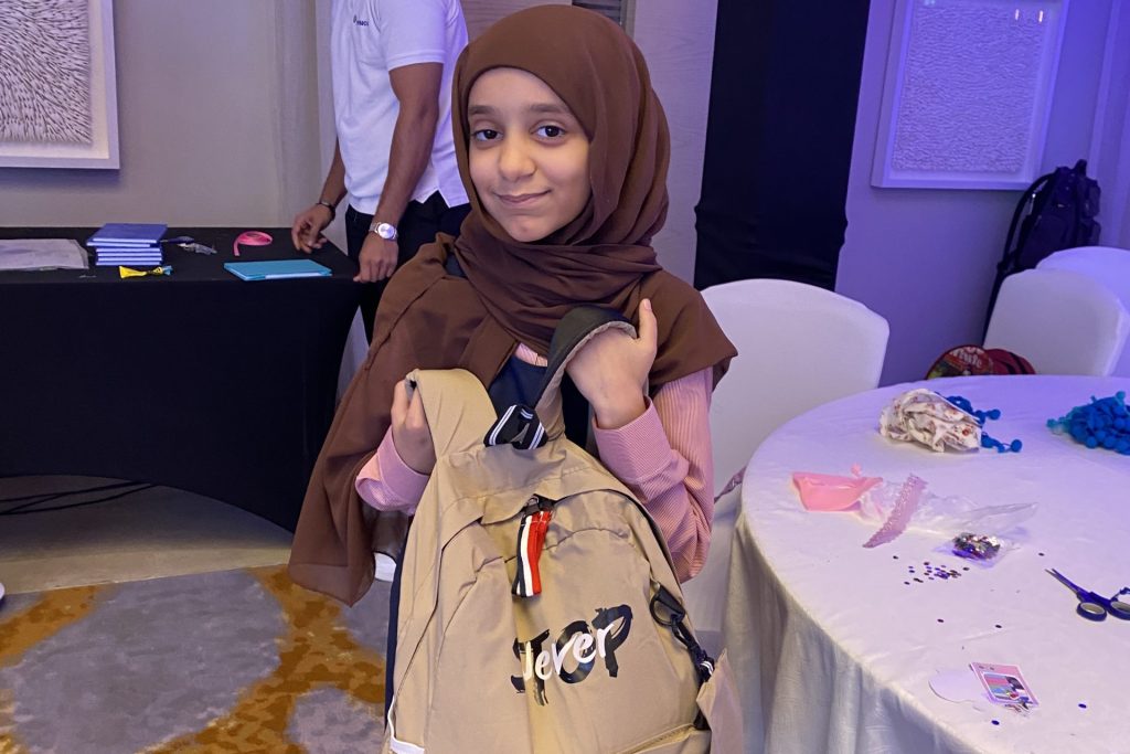 A girl child carry a bag in her hand