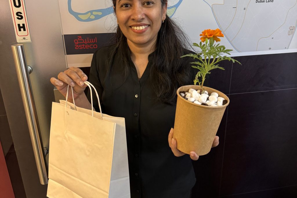 A lady with plant and gifts in her hand