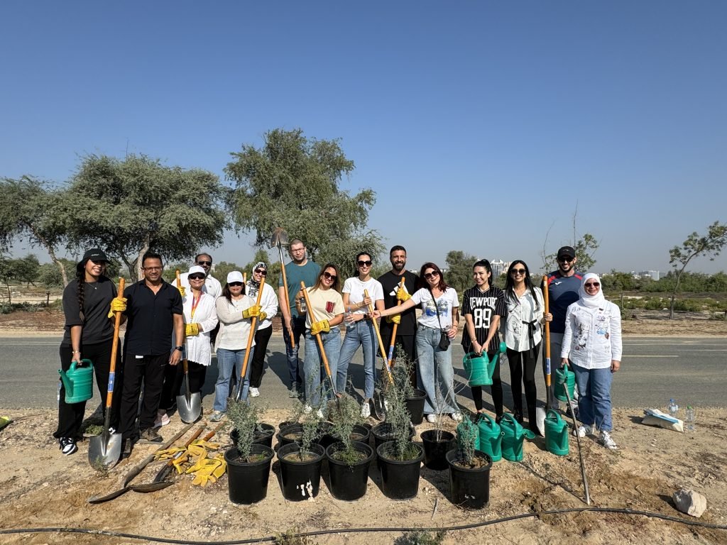 A group of people standing with shovels and gloves for a tree planting event.