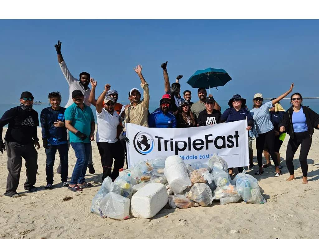 Smiling team at Dubai beach cleanup by TripleFast