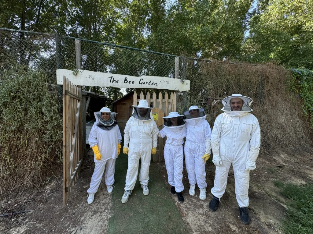 Beekeepers in protective suits at The Bee Garden gate
