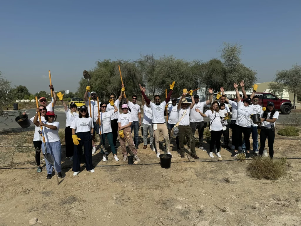 A group of people with tools and helmets ready for a community cleanup.