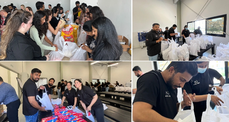 A group of individuals collaborates in a bright space, assembling packages and distributing supplies, showcasing teamwork and community effort.