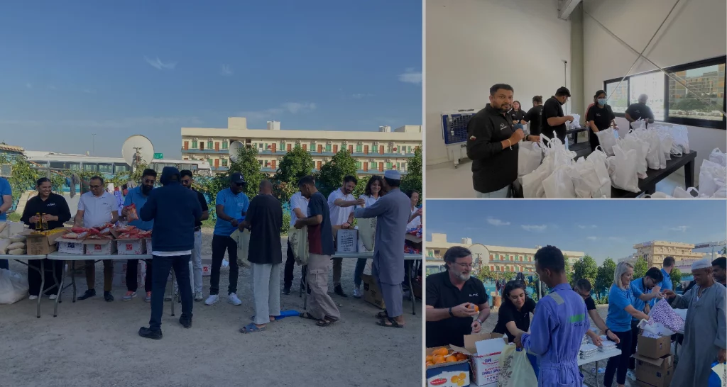A diverse group of people gathers outdoors, distributing food donations in bags, with some engaged in conversation and others preparing supplies.