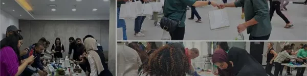 Participants engage in a creative workshop, exchanging ideas and working collaboratively with art supplies on tables.