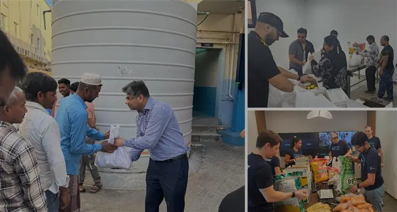 A group of people engaged in conversations and activities around a water tank, showcasing community interaction and assistance.