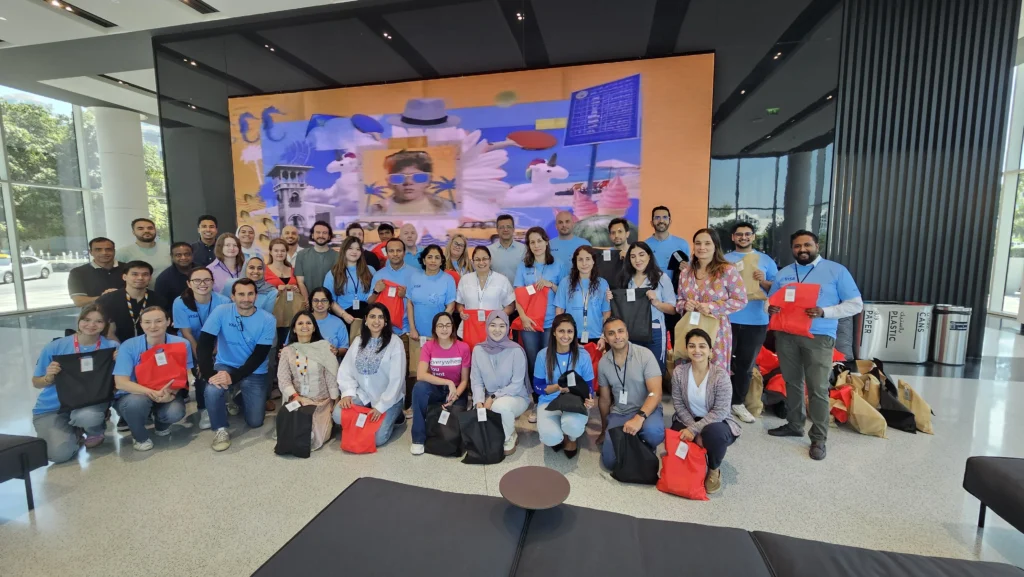 Happy crowd poses with branded gift bags