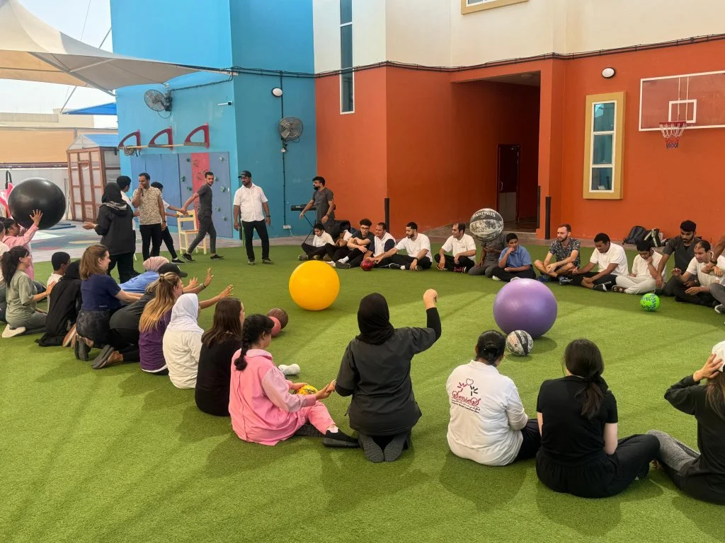 Circle of people playing with exercise balls outdoors